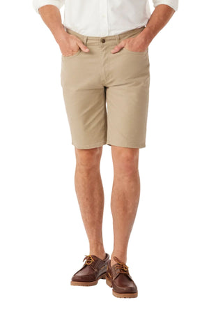 A man wearing a white shirt, RM Williams Nicholson Short in regular fit Australian stretch cotton twill, and brown boat shoes stands with hands in his pockets against a plain white background.