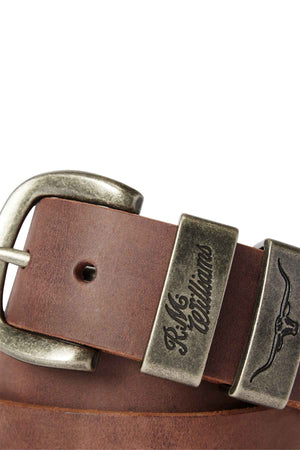 Close-up of the RM Williams Drover Belt, made with vegetable-tanned leather and a silver buckle that showcases engraved text and a steer head emblem.