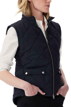 A person wears a black RM Williams Willippa Vest over a white collared shirt. Made from recycled nylon, it has quilted construction, front zipper, and snap-button pockets. They stand with hands in pockets and head slightly turned to the side.