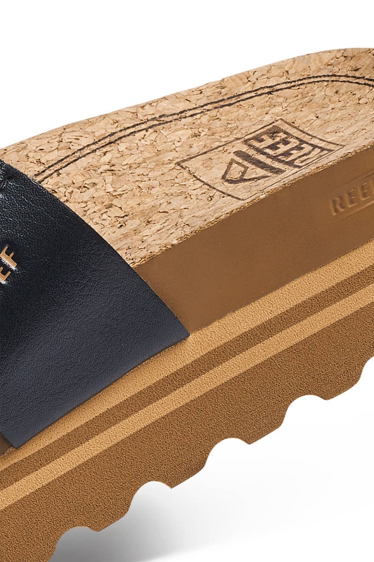 Close-up of the REEF Cushion Vista Hi sandal with a branded cork footbed, black leather strap, and a thick, textured tan sole that offers enhanced arch support.