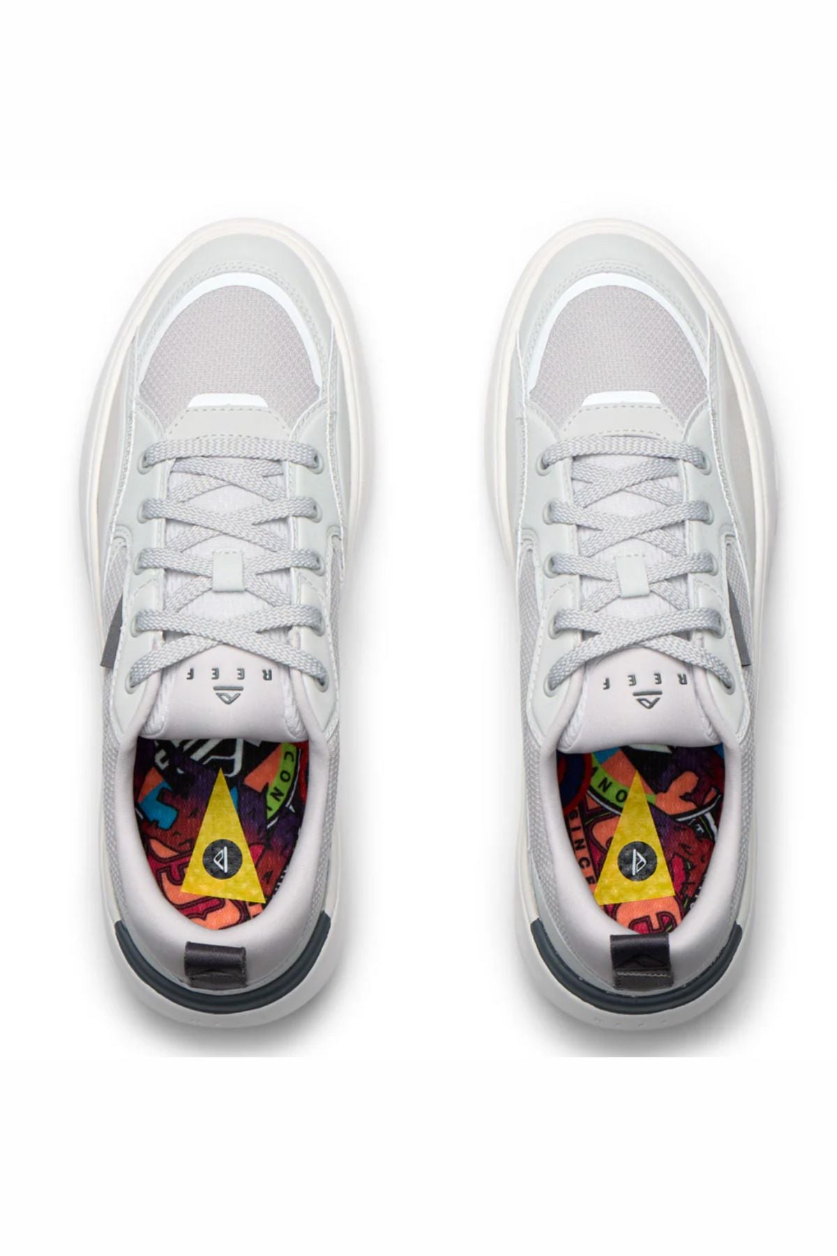 A top-down view of the Reef Fanning Mens Shoe in white with light gray accents and colorful patterned insoles, featuring abstract shapes and vibrant hues.