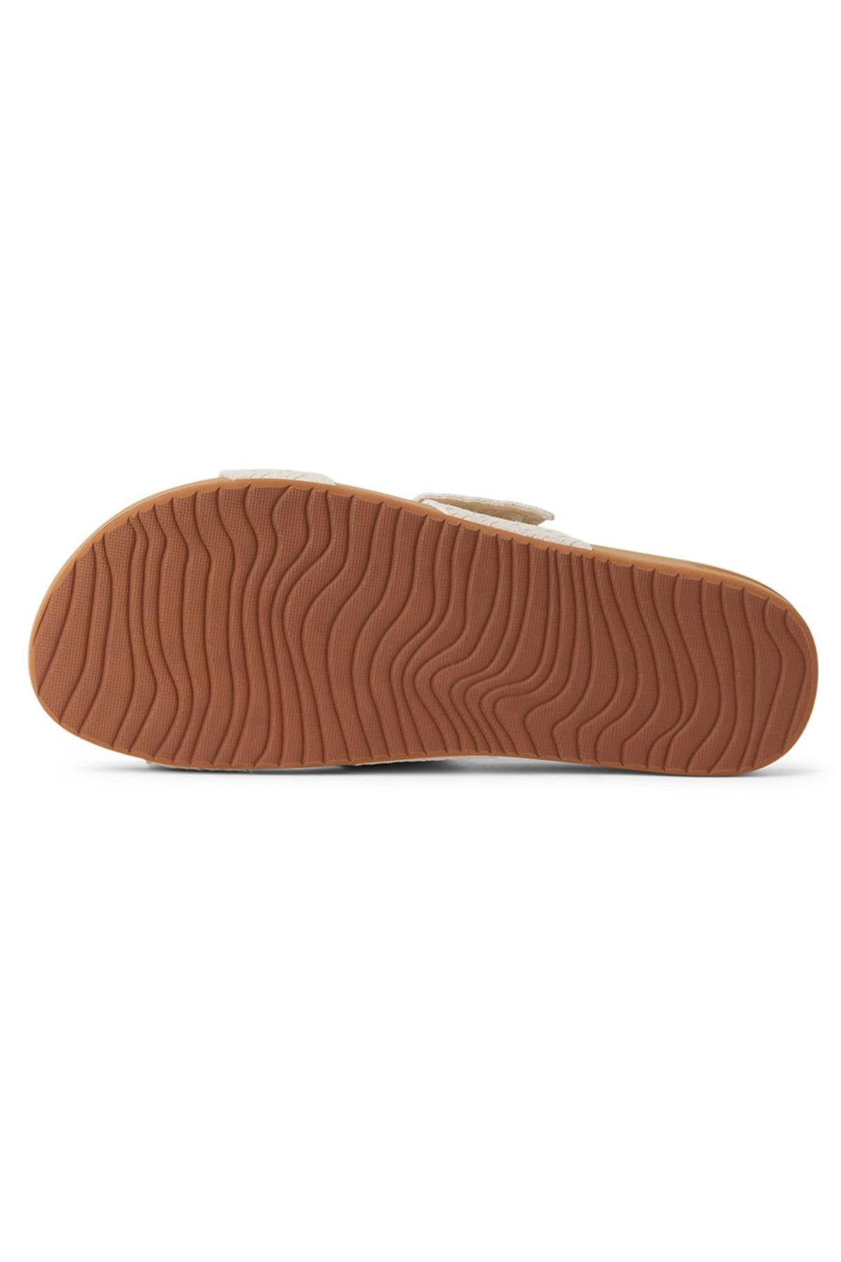 This image shows the bottom view of the REEF Velcro Vista Se sandal, highlighting its brown, textured rubber sole with wavy grooves for traction and visible cushion midsole along the edges.