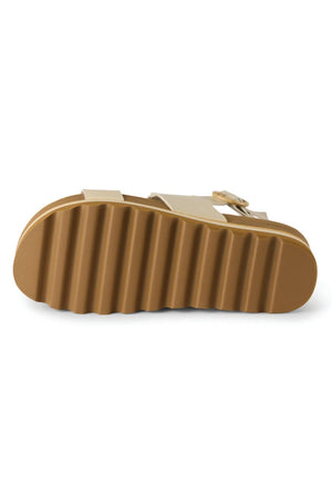 The REEF Vista Hi Buckle gold platform sandal is shown from the bottom, featuring a thick, ridged sole, built-in arch support, and partially visible two straps with a buckle for a chic look.