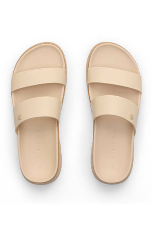 The REEF Vista Luxe Thea sandals in beige feature vegan leather, two wide straps, a minimalist modern design, and a comfortable footbed, shown from above on a white background.