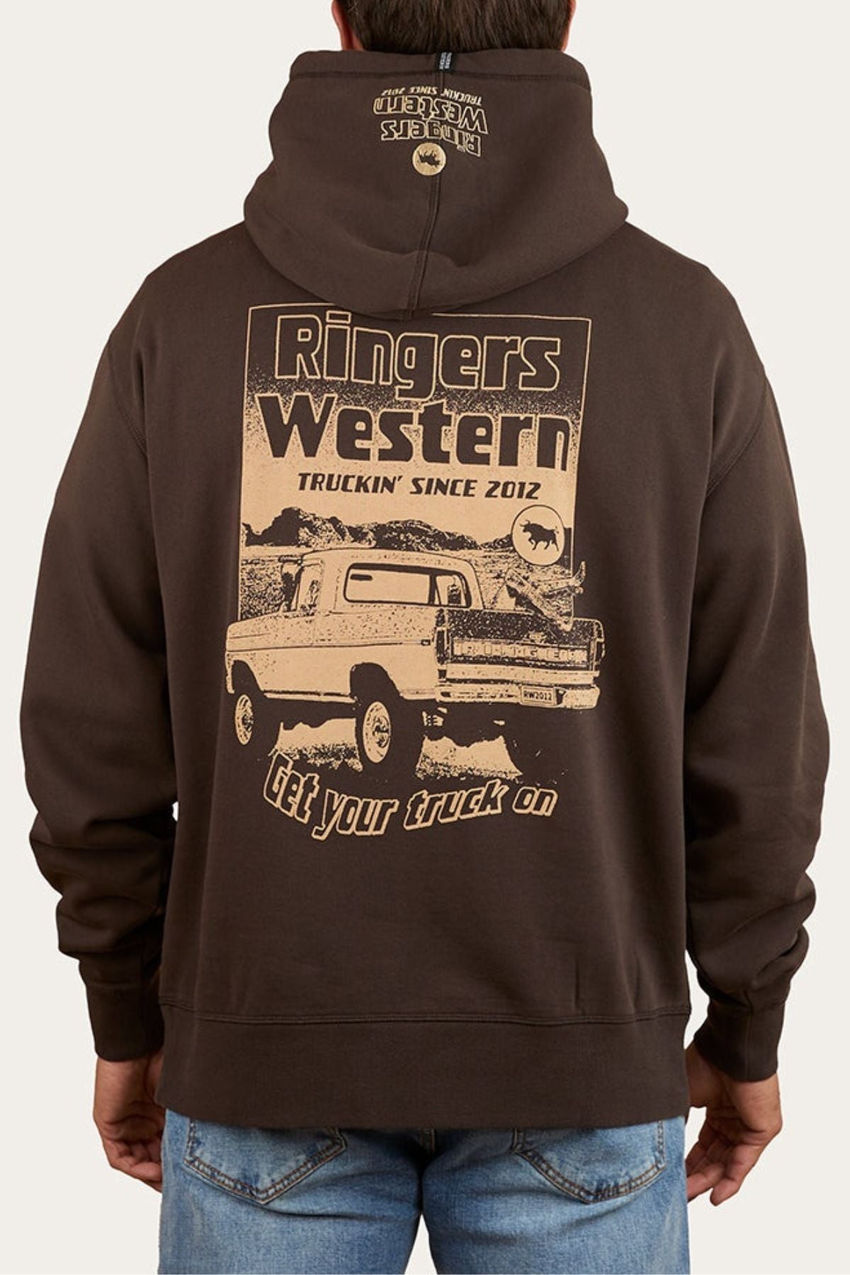 Wearing the Ringers Western Get Your Truck On Pullover Hoodie, made from premium brushed fleece, with a vintage pickup truck graphic and "Ringers Western Truckin’ Since 2012" plus "Get your truck on" text on the back, and a small logo on the hood.