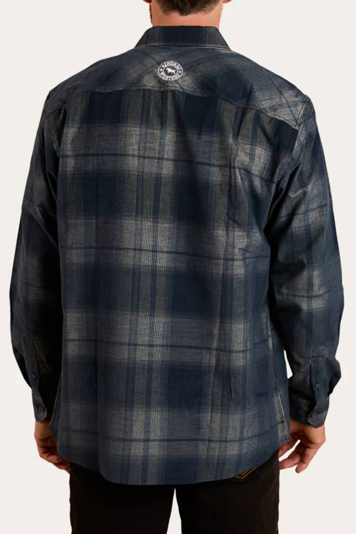 A person seen from behind wears a long-sleeve, dark blue Ringers Western Glenferrie Flannel Shirt with a circular logo near the upper center. The 100% cotton shirt drapes comfortably as their hands rest relaxed at their sides.