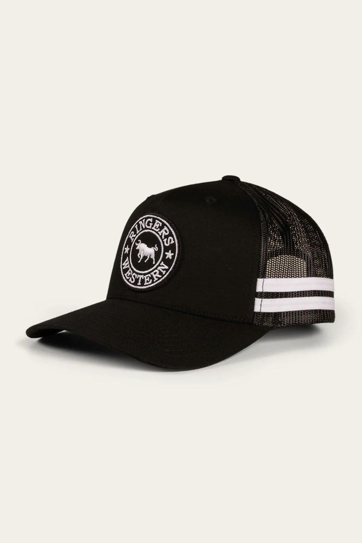 The Ringers Western McCoy Trucker Cap is a stylish black baseball cap characterized by its curved brim and breathable mesh back. It features two white stripes and sports a circular embroidered patch on the front, showcasing a bull design encircled by the words "RINGERS WESTERN.
