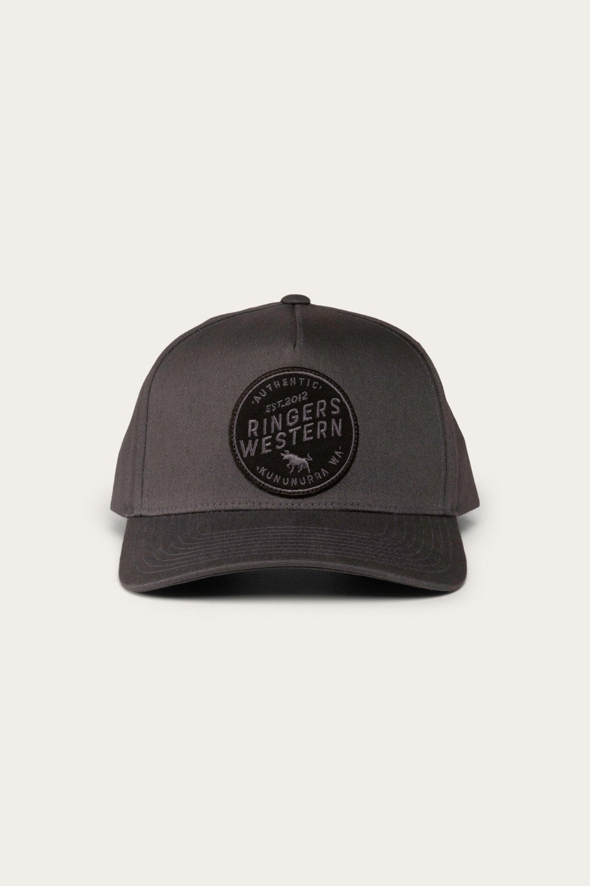 The Ringers Western Rye Baseball Cap, a black cotton twill hat, features a circular embroidered patch on the front. The patch includes the text "Authentic" at the top, "Ringers Western" in the center, and "Est. 2012" and "Kununurra, WA" below on a light grey background.
