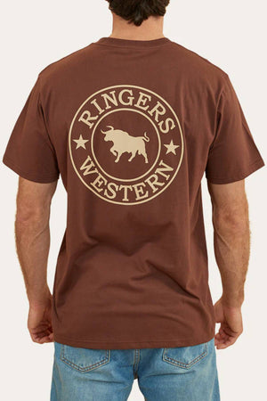 A person in blue jeans is seen from behind wearing a brown Ringers Western Signature Bull Loose Fit T-Shirt, made from 100% cotton jersey, with a large circular bull and two stars logo on the back.