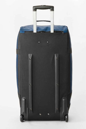 The Rip Curl Jupiter Search Ref 80L Travel Bag features a large, water-resistant navy blue fabric, black back, two wheels, two support bars, and an extended telescoping handle. The bag is shown on a plain white background.