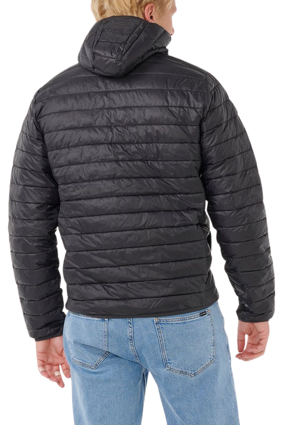 A person is shown from the back wearing the Rip Curl Anti Series Search Puffer Hood in black with a hood and light blue jeans, standing against a white background.