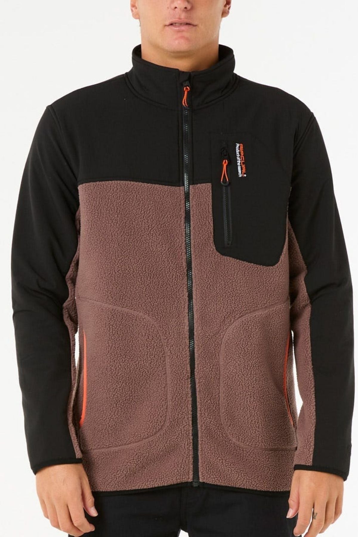 A person wearing the Rip Curl Anti Series Search Zip Crew, featuring a black top, brown textured polyester polar fleece lower section, and orange zipper accents, stands against a plain white background.