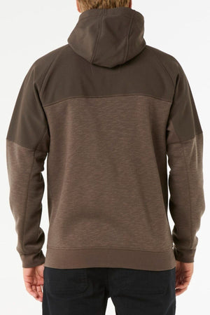 A person wearing the Rip Curl Anti Series Viral Zip Thru brown hoodie, hood down, is seen from the back standing against a plain white background.