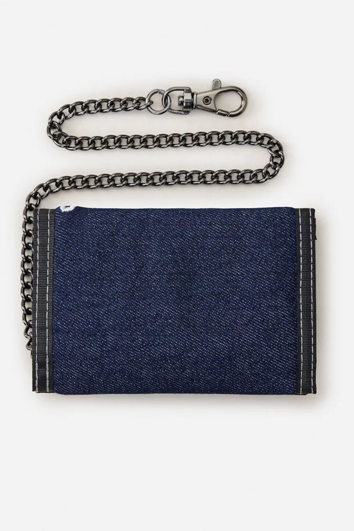 The Rip Curl Archive Denim Surf Wallet, made from blue cotton denim with black trim, features a chunky black metal chain and clasp, displayed against a plain white background.