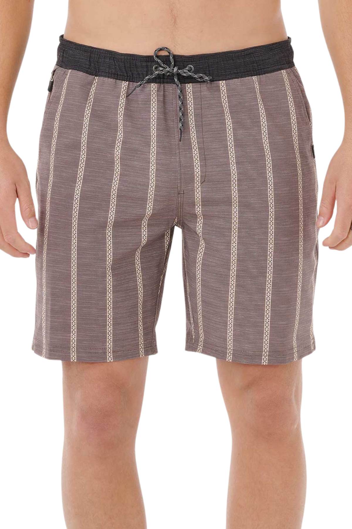 A person wears Rip Curl Boardwalk Jackson Volley shorts with brown stripes, a black waistband and drawstring, beige and white vertical patterns, above-the-knee length, and quick-dry fabric. Arms are relaxed at their sides.