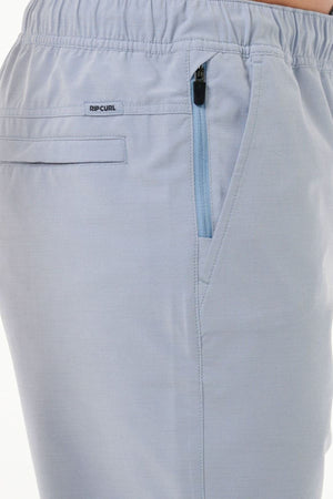 Close-up of the light blue Rip Curl Boardwalk Jackson Volley pants showcasing an elastic waistband, a zippered pocket, and a back pocket. A small "Rip Curl" logo tag is located near the waist. The quick-dry fabric feels smooth and comfortable, ideal for any adventure.