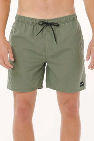 A person wears olive green Rip Curl Bondi Volley board shorts made from recycled PET, featuring a black drawstring and a small black patch near the hem, standing against a plain white background.
