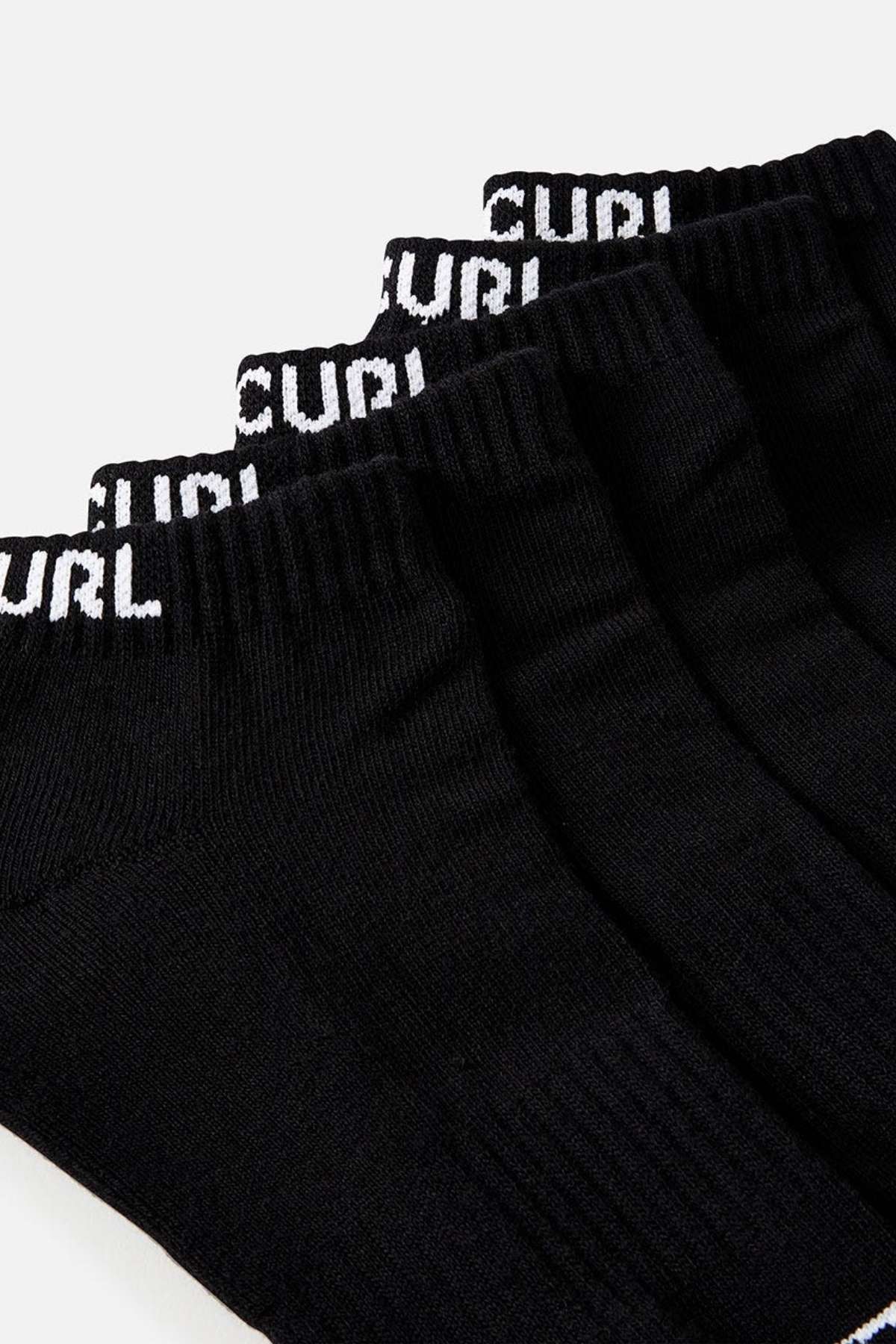 A close-up image showcases four pairs from the Rip Curl Brand Ankle Sock 5 Pack in black, each featuring white "CURL" text on the cuffs and offering arch support, set against a plain backdrop.