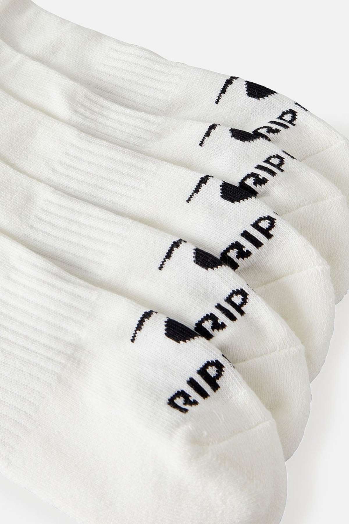 A close-up of the Rip Curl Brand Ankle Sock 5 Pack, showcasing white ankle socks with a black logo and "RIP" printed near the toes. The socks feature arch support and are neatly arranged in a row on a white surface.