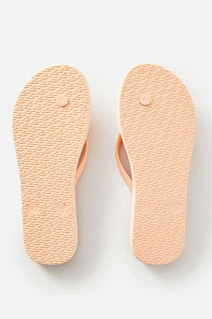 A pair of Rip Curl Classic Surf Bloom Thongs in light pink, featuring textured soles made from sustainable BLOOM™ algae-blended foam EVA, displayed from the bottom. The thongs are positioned side by side on a plain white background.