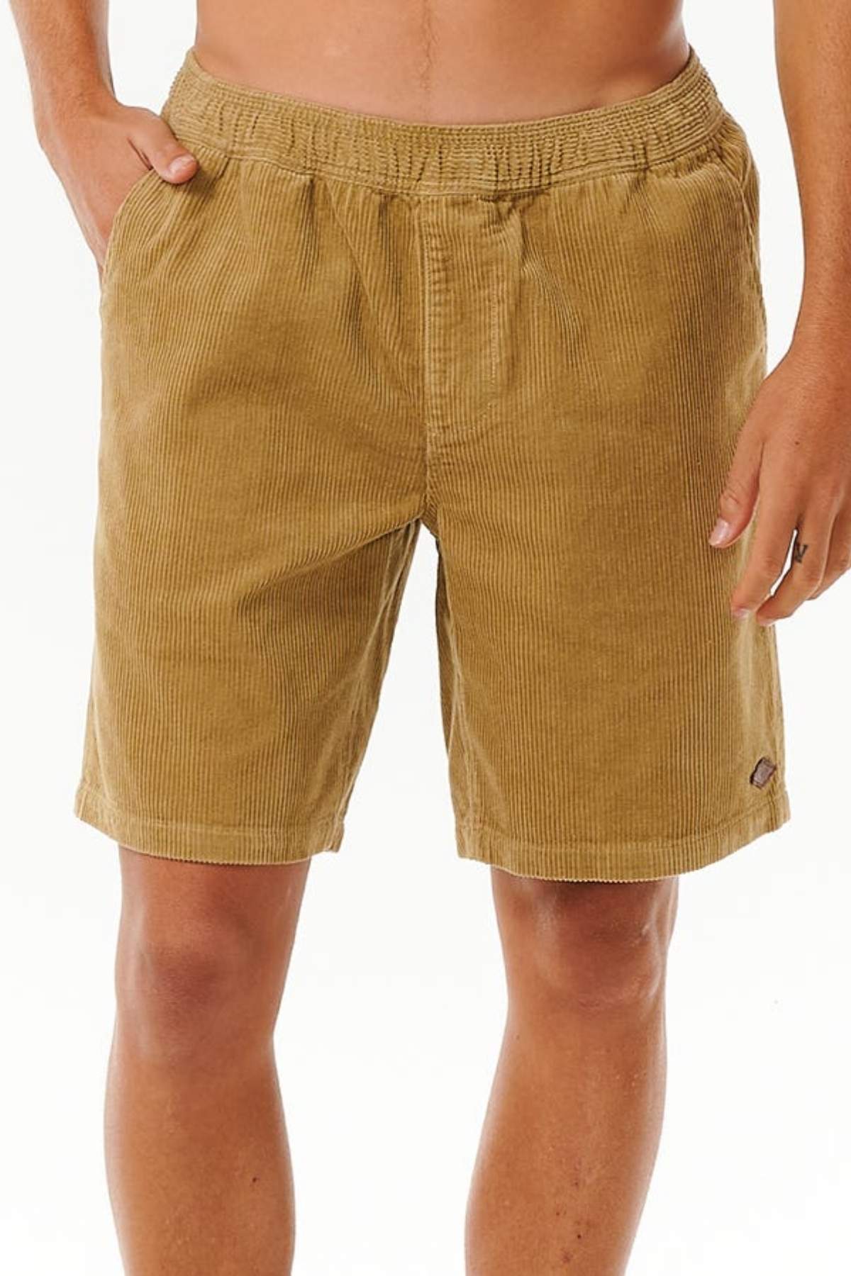 A person wearing Rip Curl Classic Surf Cord Volley shorts with an elastic waistband and side pockets, ideal for beach-casual style, stands against a plain white background.