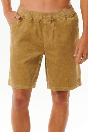 A person wearing Rip Curl Classic Surf Cord Volley shorts with an elastic waistband and side pockets, ideal for beach-casual style, stands against a plain white background.
