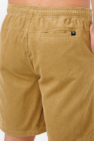 A close-up of a person wearing the Rip Curl Classic Surf Cord Volley shorts in tan OG fit, highlighting the back waistband, right rear pocket, and hand—ideal for laid-back beach style.
