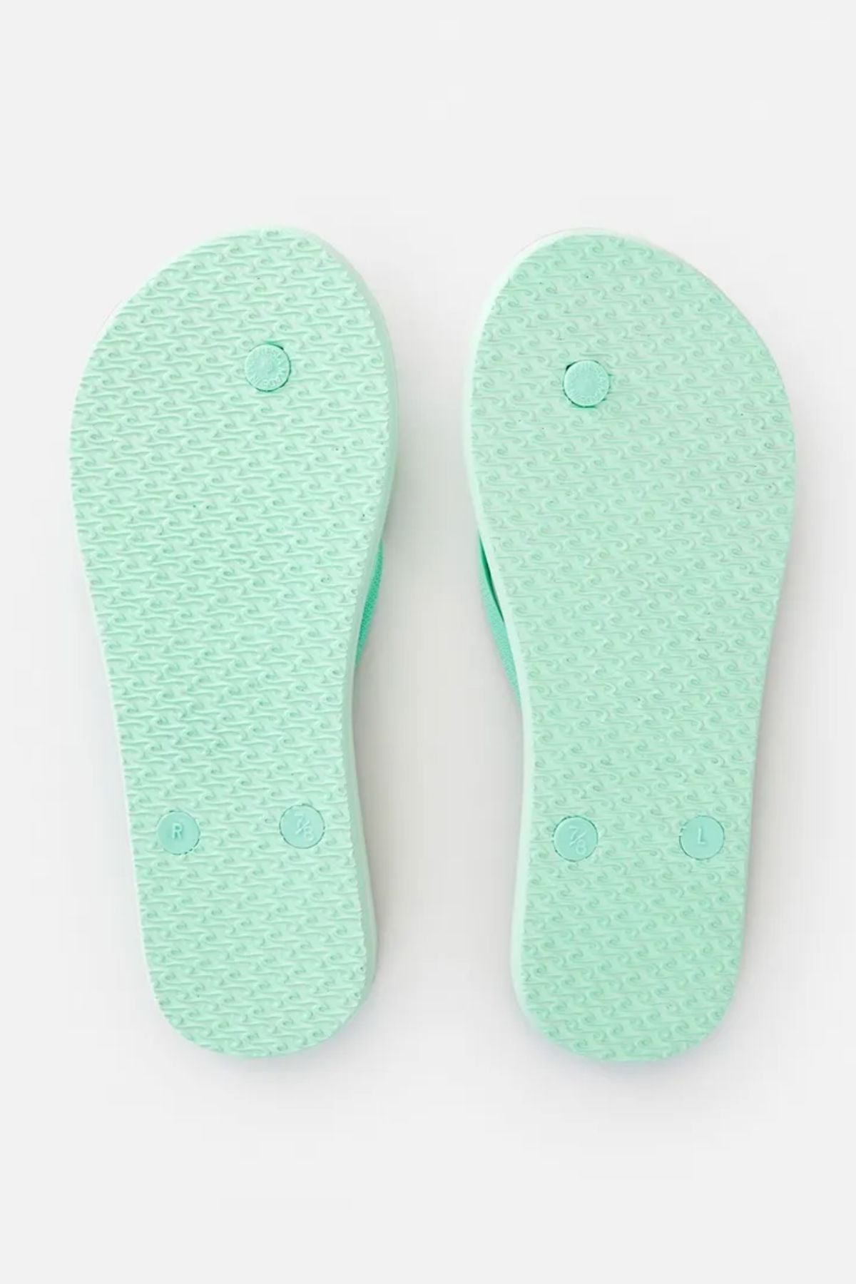 The image displays a pair of Rip Curl Classic Surf Thongs in light green, viewed from the sole side. These flip-flops have a rubber footbed with a textured pattern and designated markers for right and left.