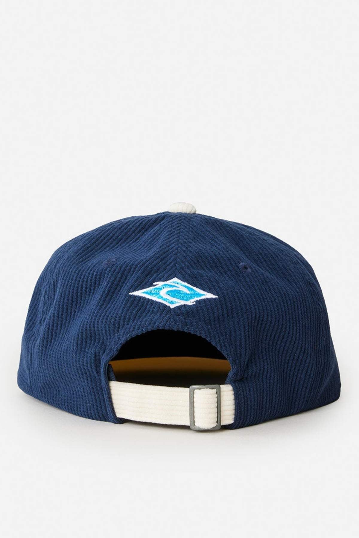 The Rip Curl Diamond Adj Cap in navy blue features 11 wale cord, a white adjustable strap with buckle at the back, and a small blue and white embroidered logo above the rear opening.