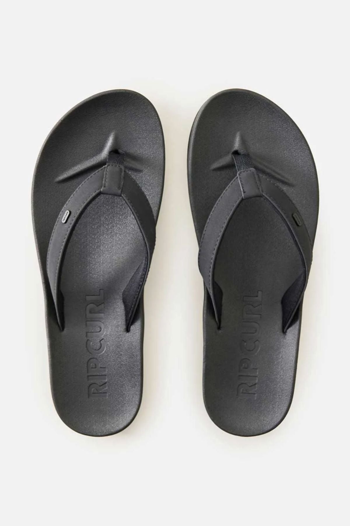 The Rip Curl Essential Contour Bloom Thongs are black with wide straps, textured soles, and a contoured footbed, shown from above on a plain light background.