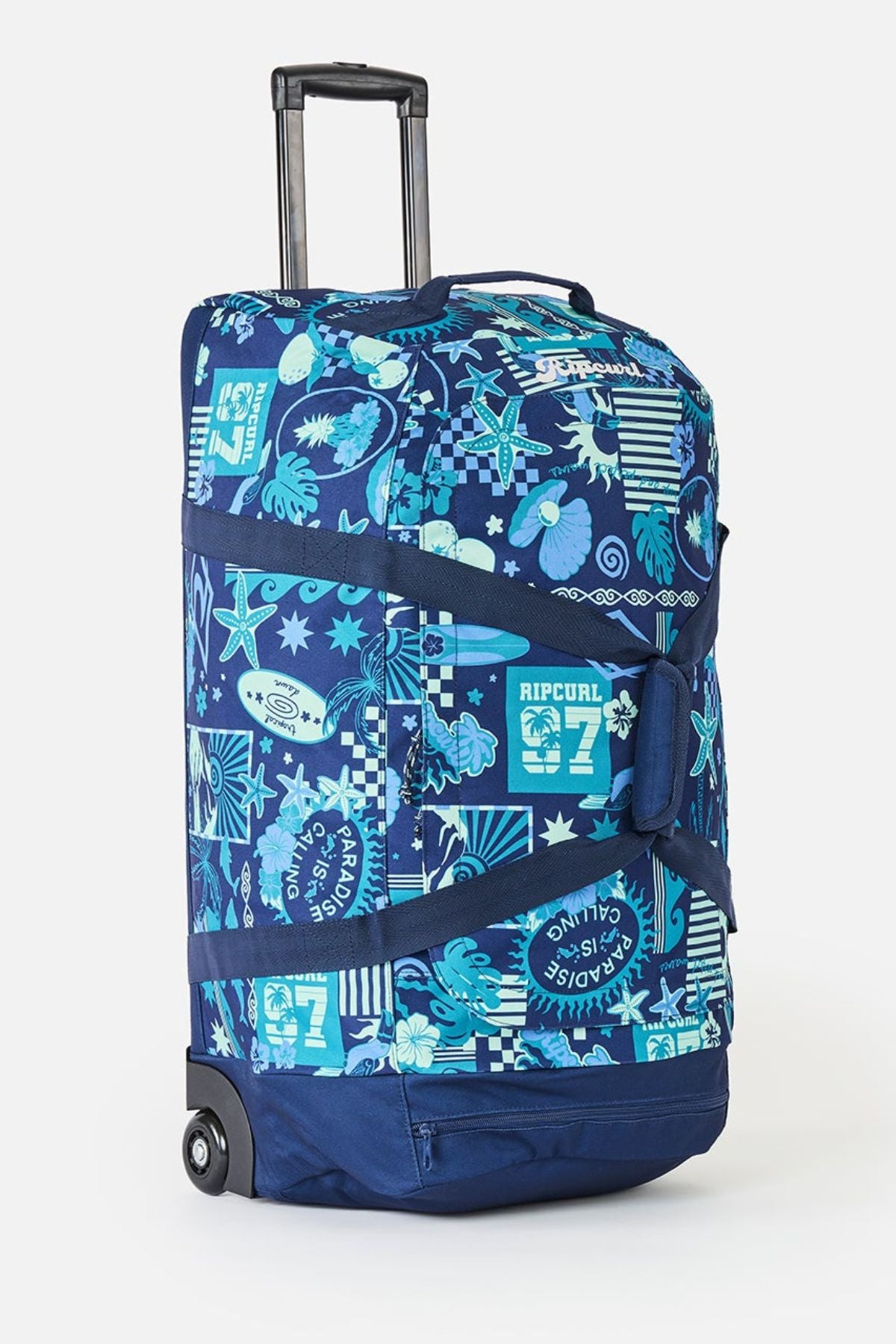 The Rip Curl Jupiter 80L Mixed Travel Bag is blue with surf and sea-themed patterns, a white turquoise logo, retractable handle, two wheels, black straps, and made from durable recycled polyester.