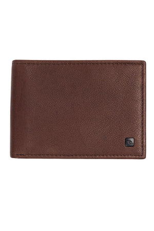 The Rip Curl K-Roo RFID Slim Wallet is a closed, brown slim wallet crafted from premium kangaroo leather, with neat edge stitching and a small black square logo at the bottom right corner.