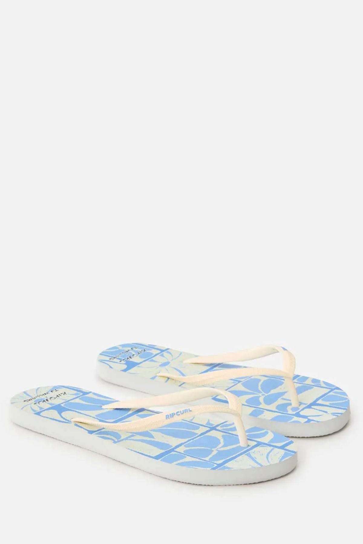 A pair of Rip Curl Mixed Bloom Thongs in light blue with white and cream straps, a geometric footbed pattern, and a comfy 3-point design, shown on a plain white background.