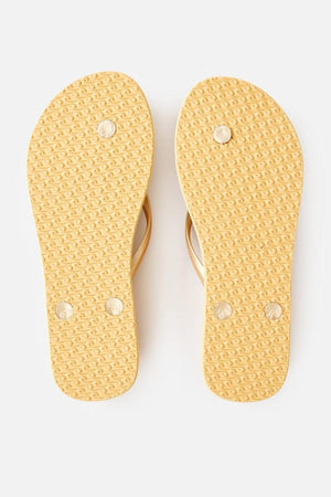 The Rip Curl Premium Surf Bloom Thongs are beige flip-flops featuring textured soles with three circular patterns on the bottom of each sandal. The beige straps, visible peeking from above the soles, are set against a neutral background.