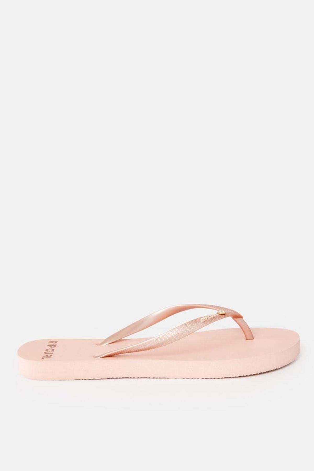 A single "Rip Curl Premium Surf Bloom Thong" in pink, featuring thin straps and a flat sole, is displayed on a plain white background. The sandal strap includes a gold-toned detail near the toe separator.