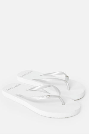 A pair of white Rip Curl Premium Surf Bloom Thongs with thin silver straps is displayed on a white background. Eco-friendly and ideal for the beach, they feature the "Rip Curl" logo printed on the footbed near the heel.