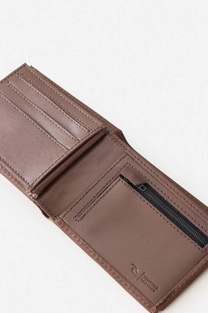 An open Rip Curl Raw Energy RFID Slim Wallet in brown leather, featuring card slots, a zippered pocket, and stitching detail, is displayed on a light background with a "Genuine Leather" label.