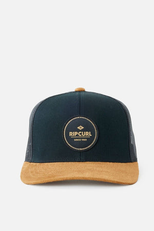 The Rip Curl Routine Curve Trucker cap showcases a "Rip Curl Since 1969" logo patch, with a black front panel and a tan suede brim. Ideal for outdoor activities, it features mesh sides and back for breathability, complemented by herringbone spandex for added style.