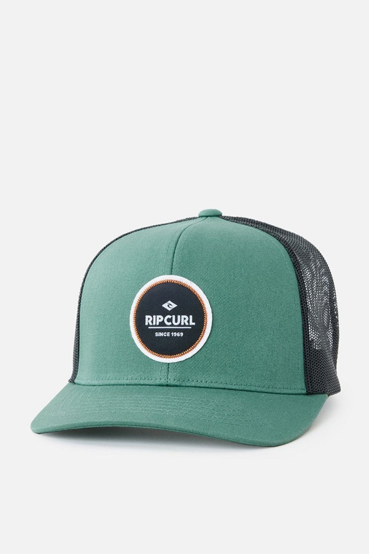 The Rip Curl Routine Curve Trucker is a green and black trucker cap featuring a round "Rip Curl" logo patch on the front, making it an ideal choice for any outdoor activity. It boasts a green front panel and bill, paired with a black mesh back and adjustable snapback closure.