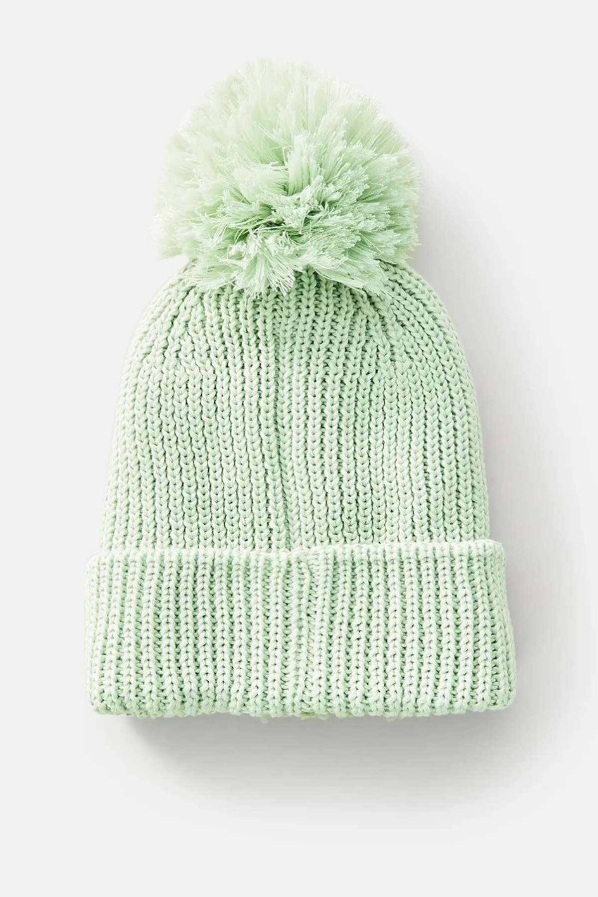 Presenting the Rip Curl Sol Seeker Pom Pom Beanie in mint green, this stylish accessory features a large pom-pom at the top and is adorned with a cozy teddy fur lining. Crafted from recycled polyester, it's displayed against a plain white background.