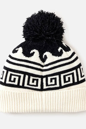 The Rip Curl Soleil Regular Pom Pom Beanie is a black and white knit beanie with a large black pom-pom, Greek key and wave intarsia patterns, and a ribbed white fold-over brim.