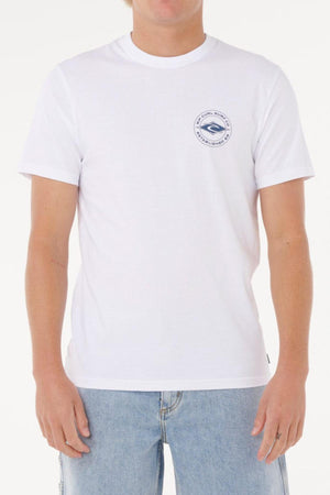 A person wearing the Rip Curl Staple Tee—a plain white cotton jersey t-shirt with a small circular blue logo on the left chest—paired with light blue denim jeans, standing against a white background.