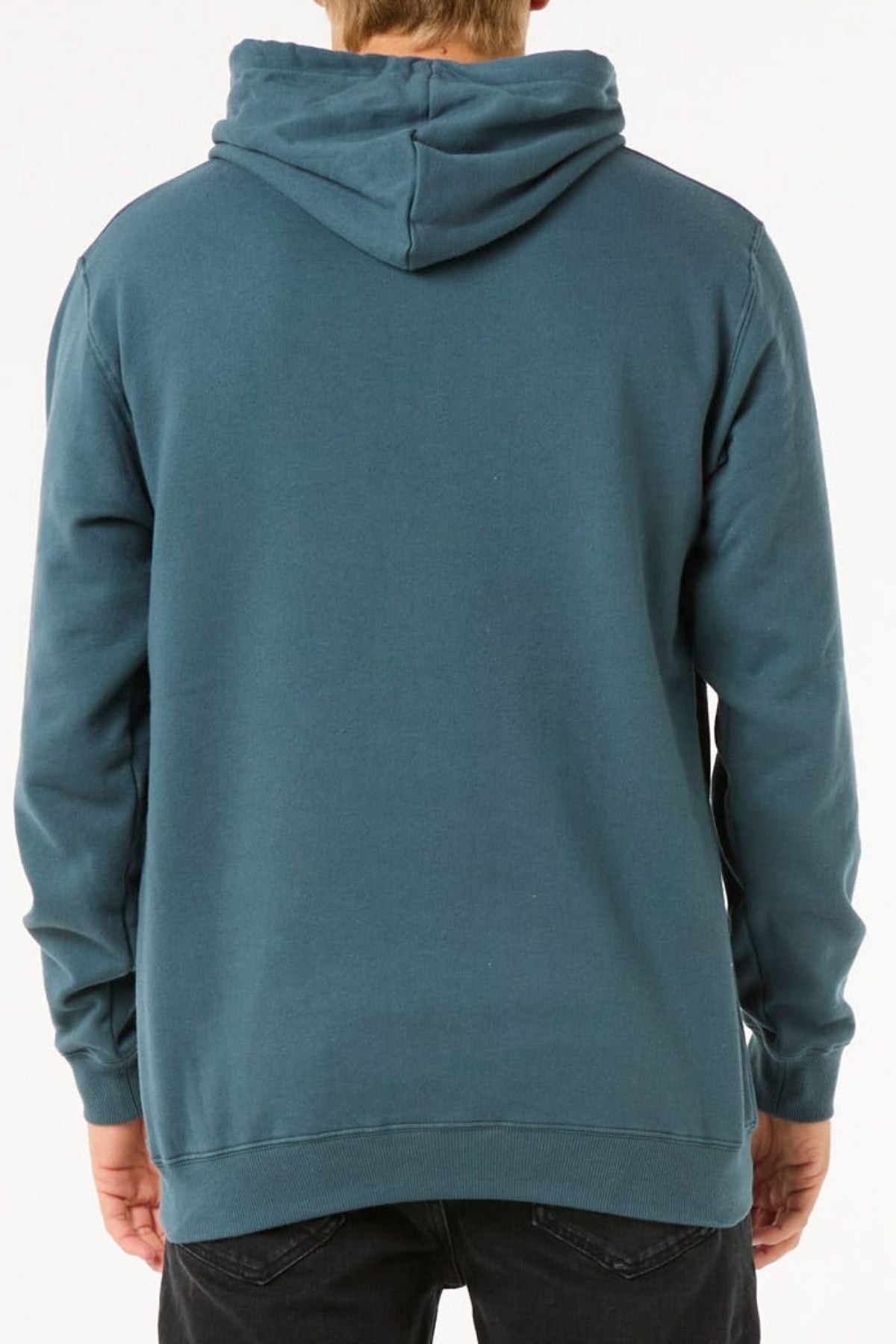 Someone is seen from the back against a white background wearing a teal Rip Curl Stapler Hood hoodie, made from cotton and polyester fleece, with black pants. The hood is up but not covering their head.