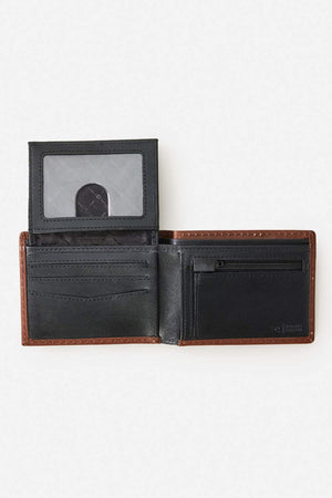 The Rip Curl Surf Revival RFID All Day Wallet is a brown leather wallet with a black interior and brown edges, featuring multiple card slots, a zippered pocket, a transparent ID window, and RFID protection. Shown on a plain white background.