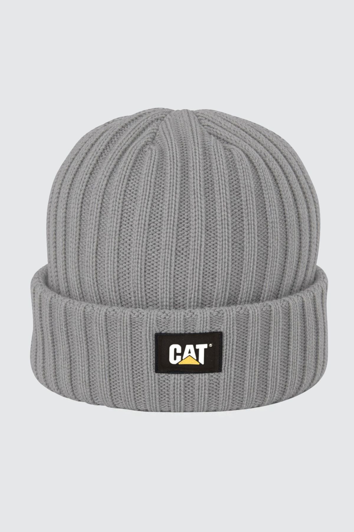 The CAT Rib Watch Beanie is gray with a ribbed knit texture and folded brim, featuring a black rectangular patch with the yellow and white CAT logo on the front.