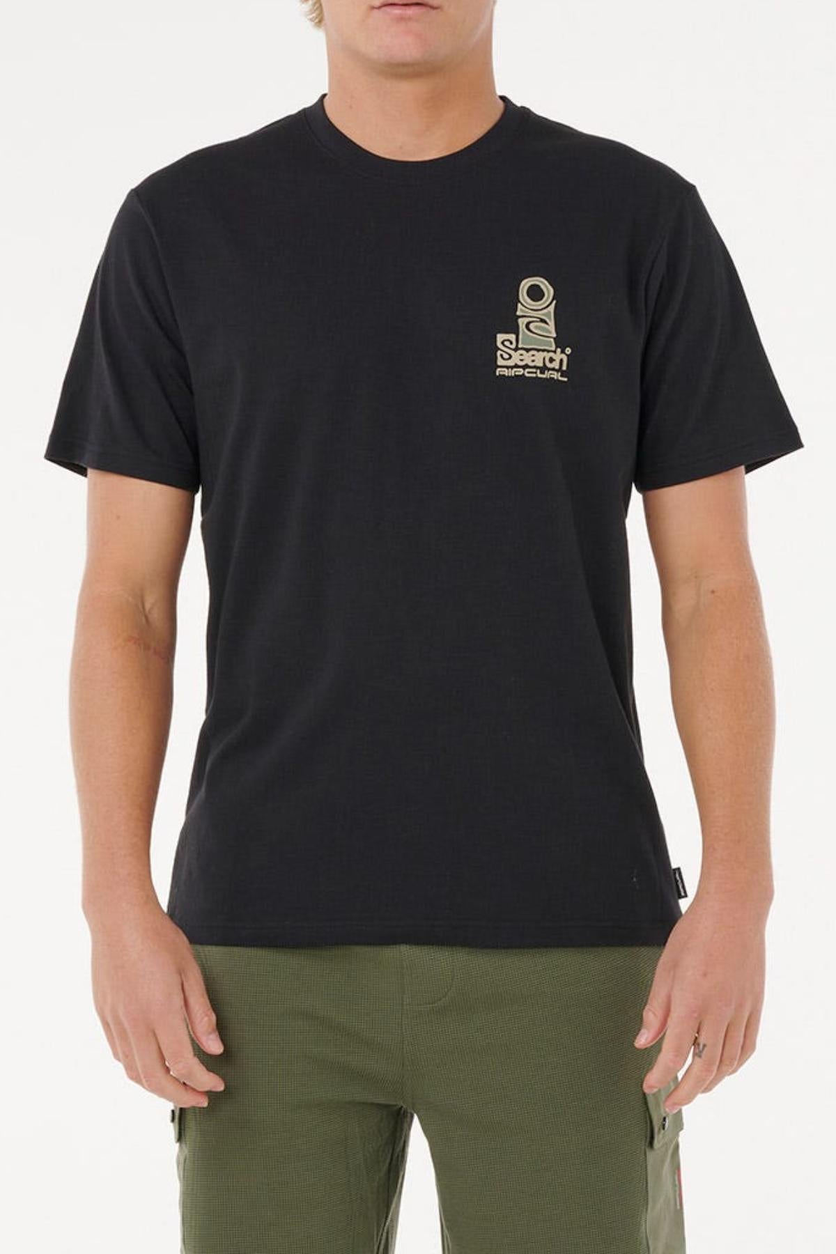 A person wears a black Rip Curl Vaporcool Search Stack Tee with a small tan graphic and text on the left chest, known for quick drying and moisture control, paired with olive green pants, standing against a plain white background.