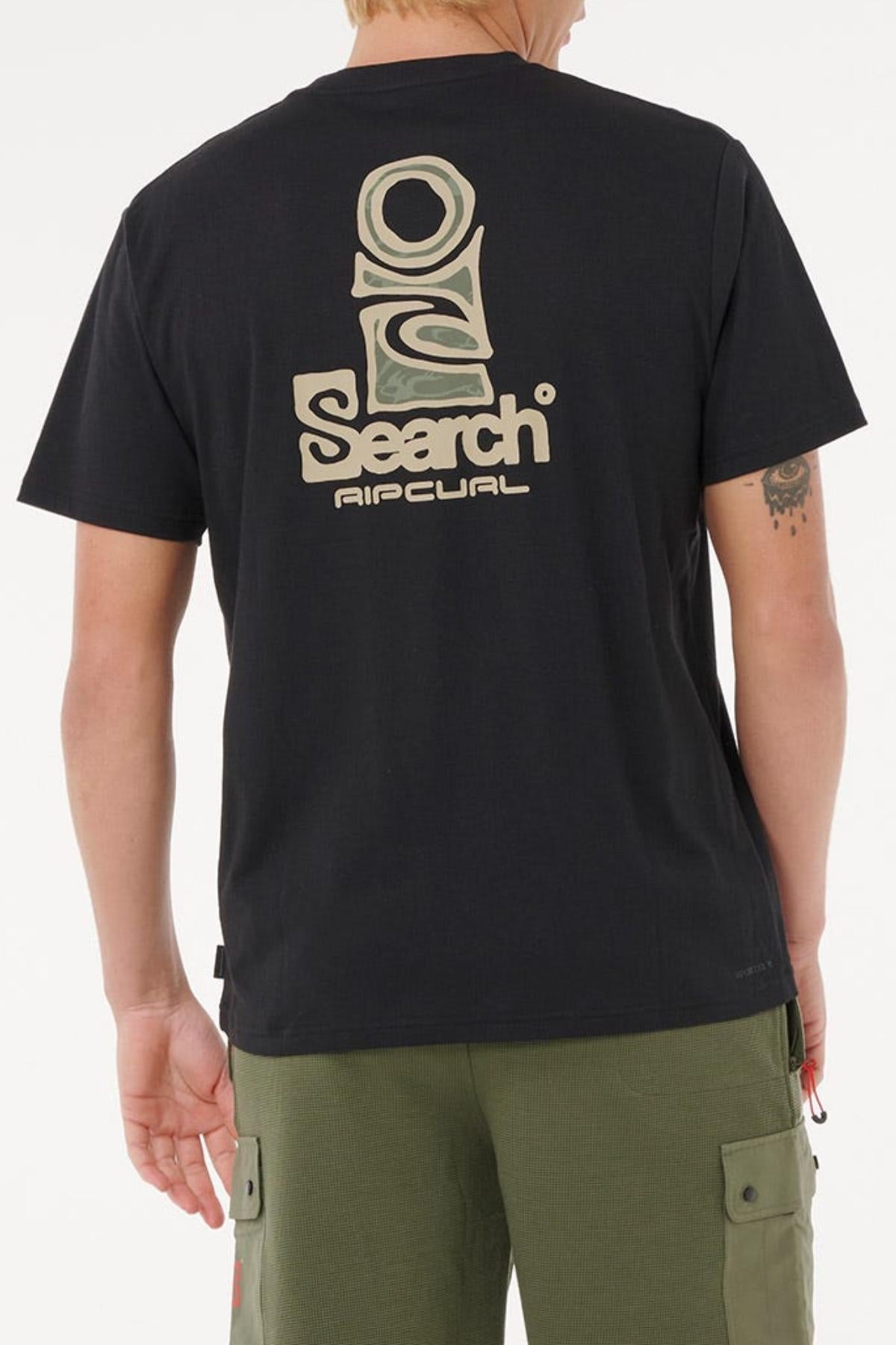 A person faces away, wearing a black Rip Curl Vaporcool Search Stack Tee with a large beige and green logo and “Search Rip Curl” on the back. This quick-drying shirt pairs with olive cargo shorts for excellent moisture control.