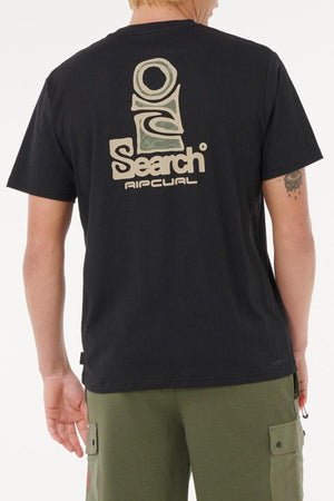 A person faces away, wearing a black Rip Curl Vaporcool Search Stack Tee with a large beige and green logo and “Search Rip Curl” on the back. This quick-drying shirt pairs with olive cargo shorts for excellent moisture control.