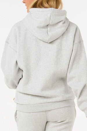 A person with blonde hair is shown from the back against a plain white background wearing a light gray Rip Curl Varsity Hoodie made from Cotton Poly Fleece with an adjustable drawcord, paired with matching sweatpants.