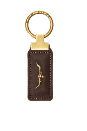 The RM Williams Angaston Key Ring is a rectangular brown smooth leather keychain with visible stitching, featuring a small gold longhorn logo accent and a gold metal ring.